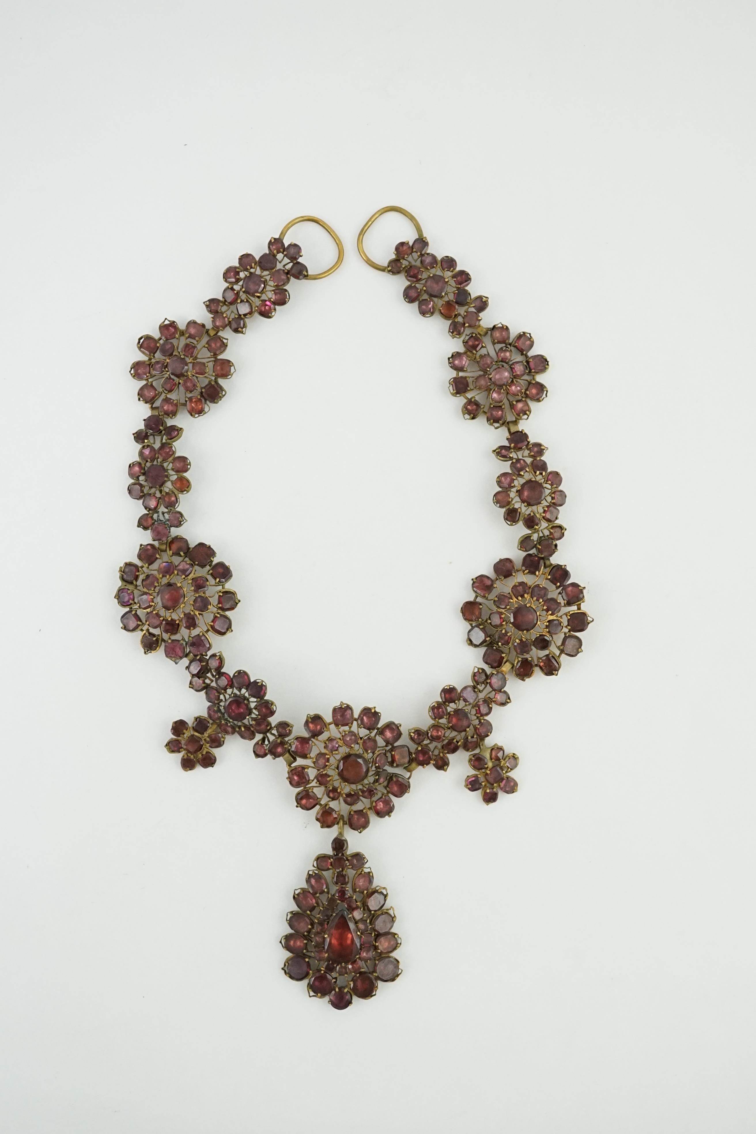 A good 18th century gilt metal and foil backed garnet cluster drop necklace, in original box